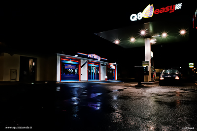 Distributore di benzina con auto nella notte