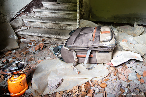 Foto di una valigia in una casa abbandonata