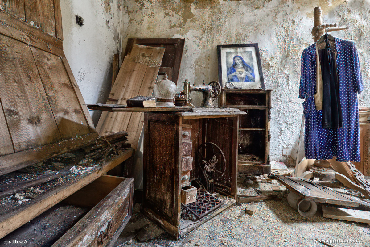 Foto di una macchina da cucire, un libro ed una immagine sacra nella casa della sarta