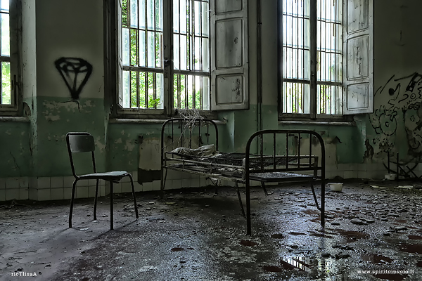Letto e sedia nel manicomio abbandonato di Volterra