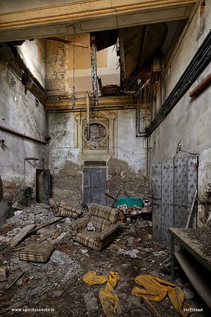 Soffitto crollato e poltrona nel palazzo abbandonato dello scultore